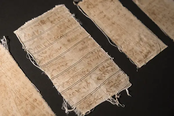 Photo credit:  When Mansour Omari was released from prison in Syria, he smuggled out these scraps of cloth sewn within the shirt he was wearing. The names of his cellmates are written on them with an ink made from blood and rust. US Holocaust Memorial Museum